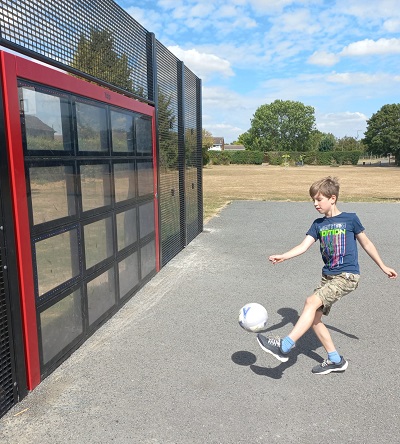 Child kicking a ball at interactive football wall