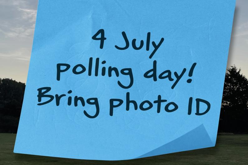 Blue note paper that has writing on it saying: 4 July polling day! Bring photo ID