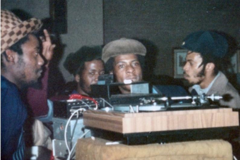 Members of the black community around a record player